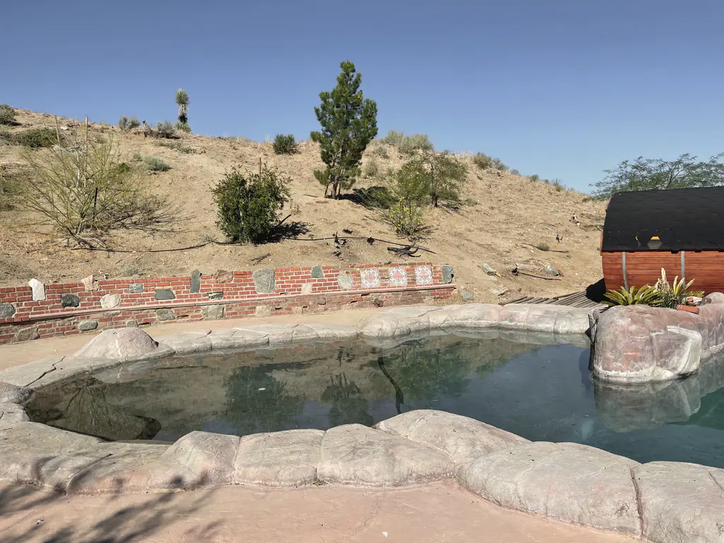 The rock pool beneath a hillside of desert plants